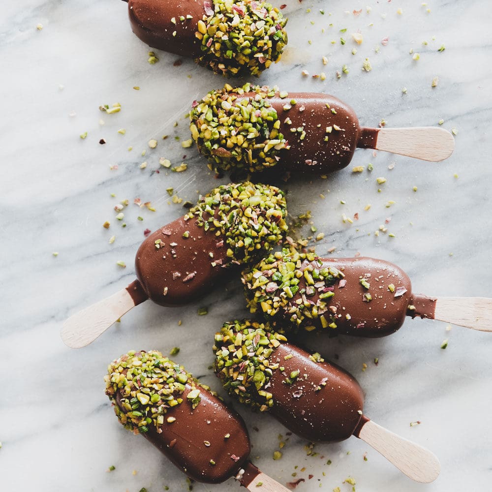 Coconut Ice Cream Popsicles Dipped in Chocolate and Chopped Pistachios